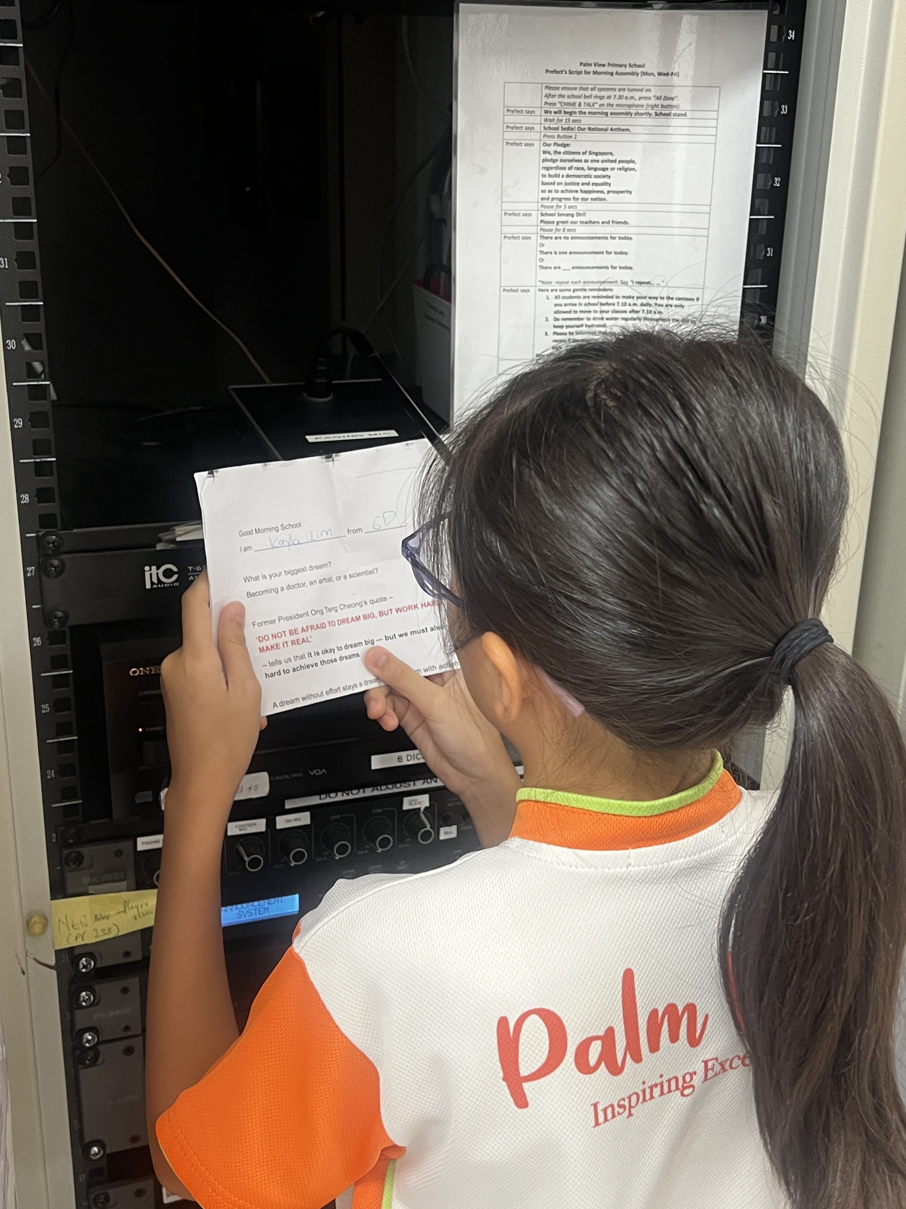 Girl reading a quote on resilience over the PA system
